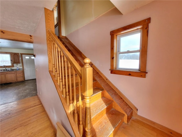 stairway featuring baseboards and wood finished floors