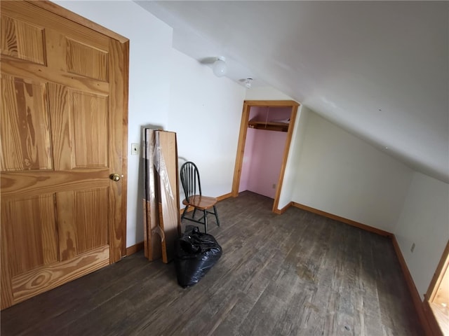 bonus room featuring lofted ceiling, dark wood-style flooring, and baseboards