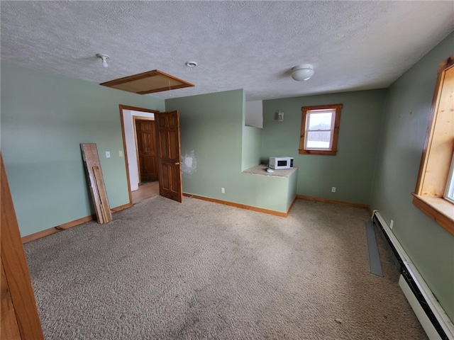 unfurnished room featuring a baseboard heating unit, a textured ceiling, carpet flooring, and baseboards