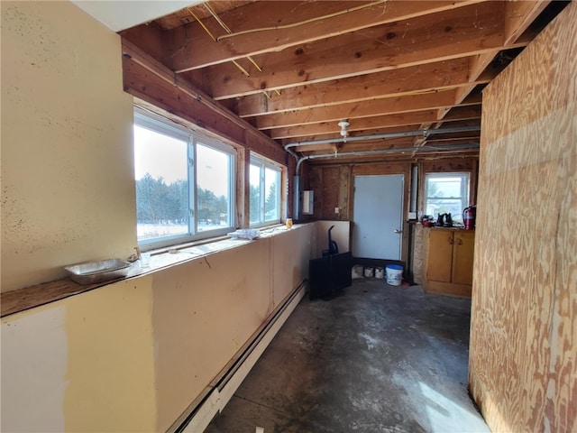 miscellaneous room featuring a baseboard heating unit and concrete flooring