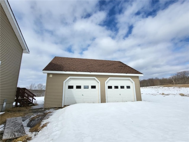 snow covered garage with a garage