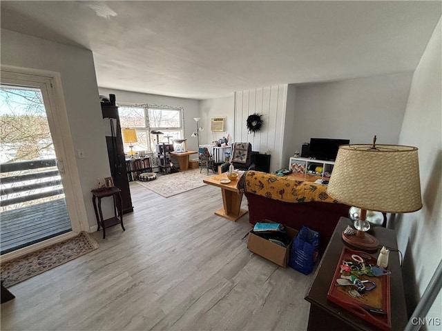 living area featuring wood finished floors and a wall mounted AC