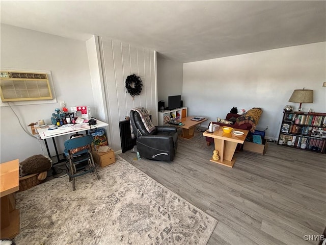 living area featuring wood finished floors and a wall mounted AC