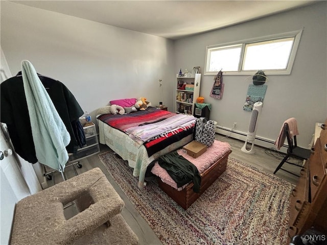 bedroom featuring a baseboard radiator and wood finished floors