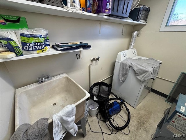 laundry area with laundry area, a sink, washer / dryer, and baseboards