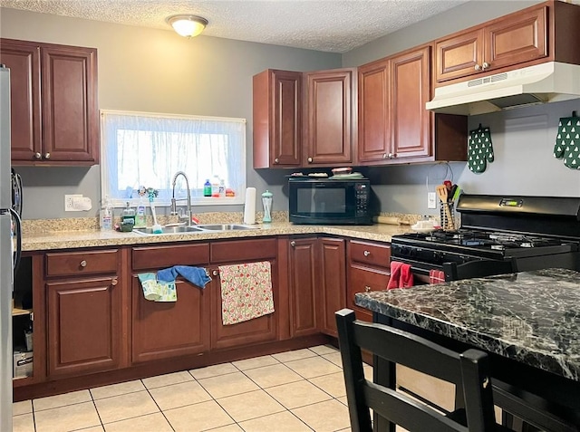 kitchen with range with gas cooktop, a sink, a textured ceiling, black microwave, and under cabinet range hood