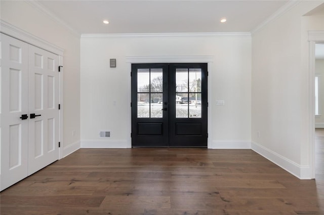 entryway with baseboards, visible vents, wood finished floors, and ornamental molding