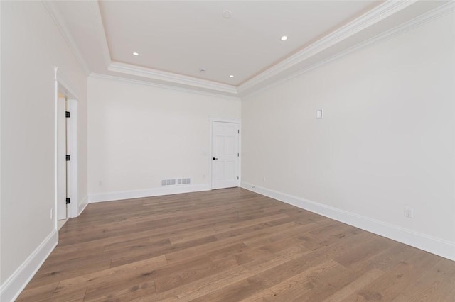 unfurnished room with ornamental molding, visible vents, and wood finished floors