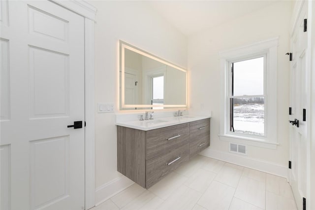 full bathroom featuring double vanity, baseboards, visible vents, and a sink