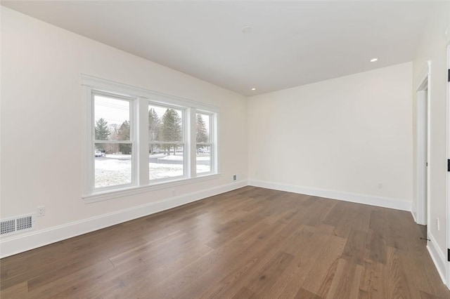 spare room featuring recessed lighting, wood finished floors, visible vents, and baseboards