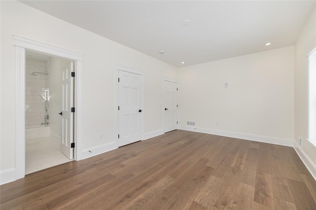 empty room with recessed lighting, visible vents, baseboards, and wood finished floors