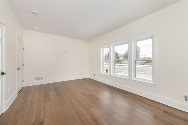 spare room featuring baseboards, visible vents, wood finished floors, and recessed lighting