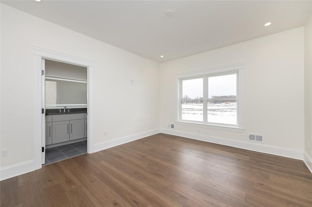 unfurnished bedroom featuring baseboards, visible vents, dark wood-type flooring, and recessed lighting