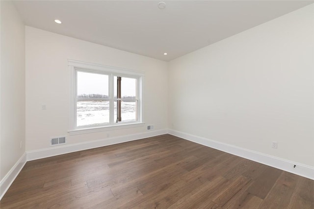 spare room with baseboards, visible vents, dark wood-type flooring, and recessed lighting