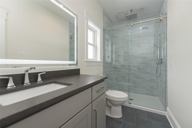 full bath featuring toilet, vanity, a shower stall, baseboards, and tile patterned floors