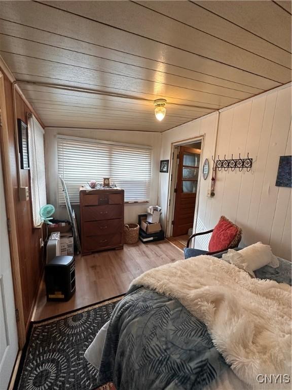 bedroom featuring wood walls, wood finished floors, and wood ceiling