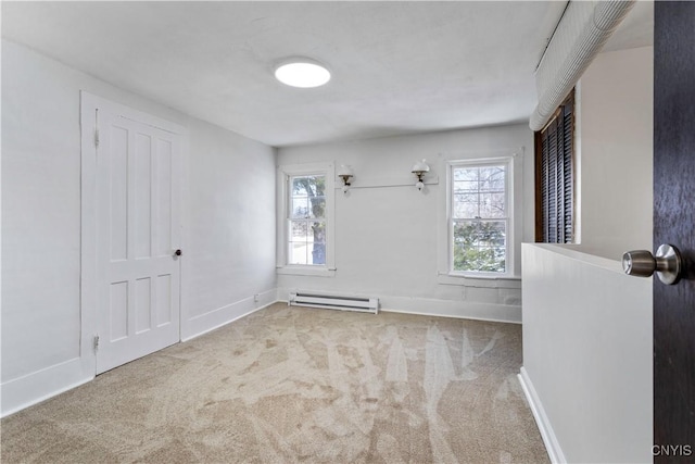 carpeted spare room featuring a baseboard radiator and baseboards