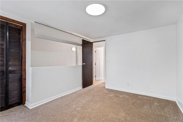 unfurnished bedroom featuring carpet floors, a closet, and baseboards