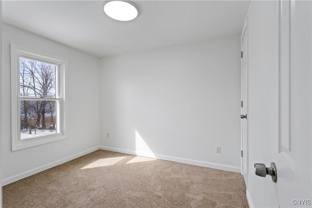 carpeted spare room featuring baseboards