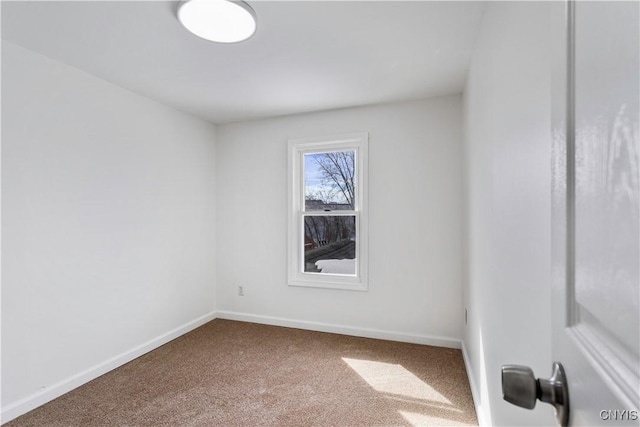 spare room featuring carpet floors and baseboards