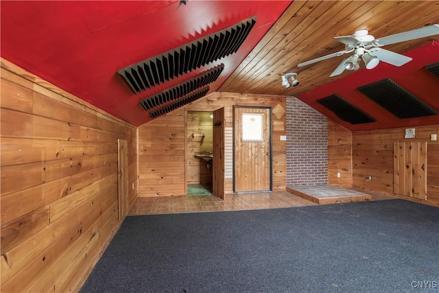 bonus room with lofted ceiling, carpet, wooden walls, and a ceiling fan