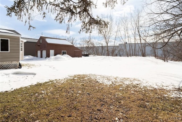 snowy yard featuring an outbuilding