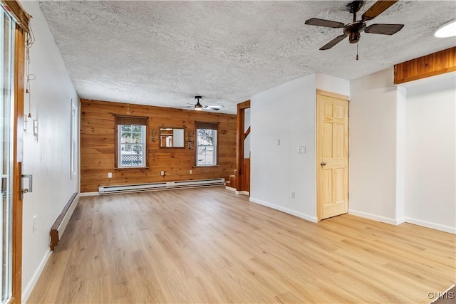 unfurnished living room featuring a baseboard heating unit, a textured ceiling, a baseboard radiator, and light wood-style floors