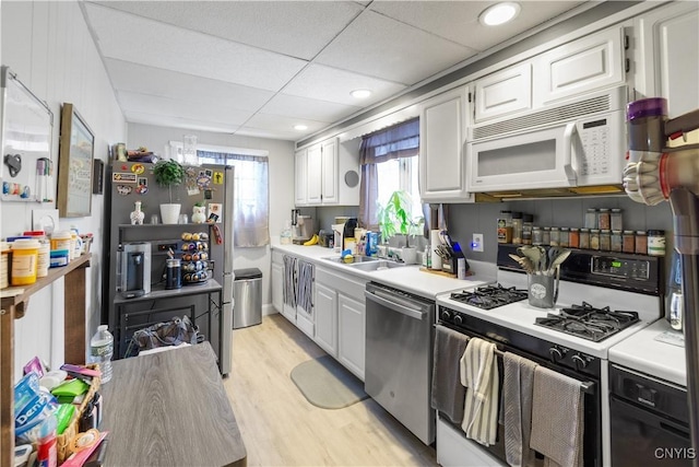 kitchen featuring light wood-style floors, white appliances, light countertops, and white cabinetry