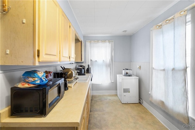 clothes washing area featuring laundry area and a wainscoted wall