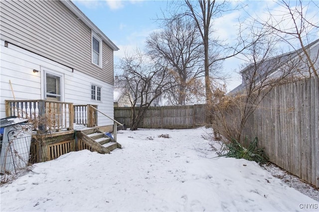 snowy yard featuring a fenced backyard