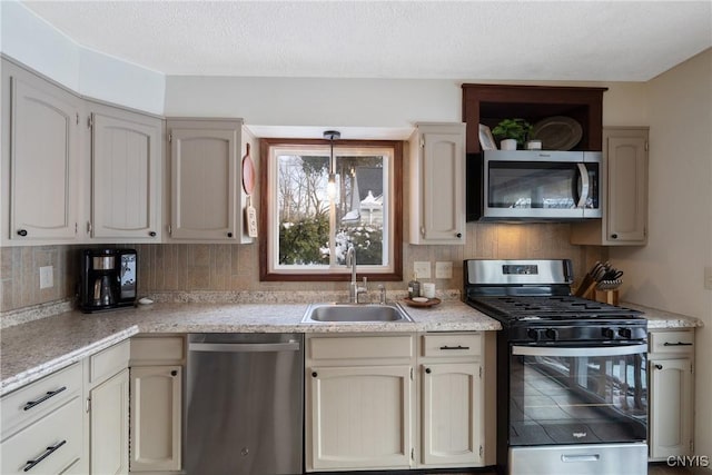 kitchen featuring appliances with stainless steel finishes, decorative backsplash, a sink, and light countertops