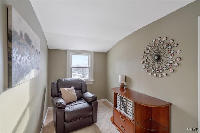 living area with vaulted ceiling and baseboards