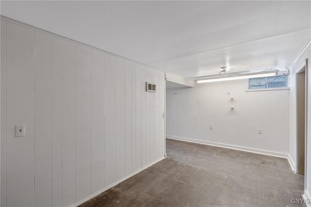 basement featuring baseboards, visible vents, and wood finished floors