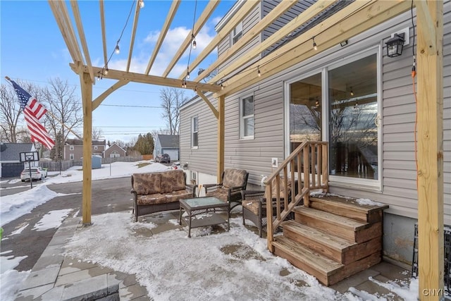 snow covered patio with an outdoor living space and a pergola