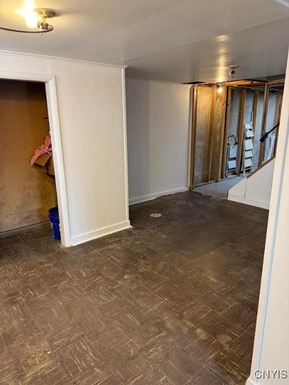 basement featuring baseboards and tile patterned floors