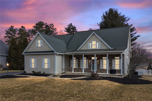 view of front facade featuring fence, a porch, and a front yard