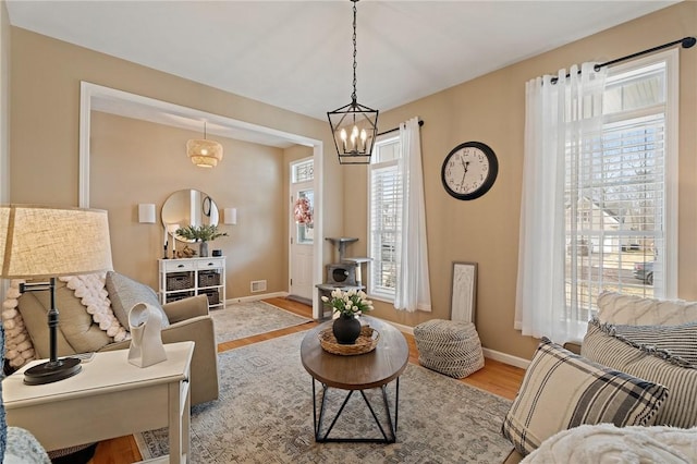 living area featuring baseboards, visible vents, and wood finished floors