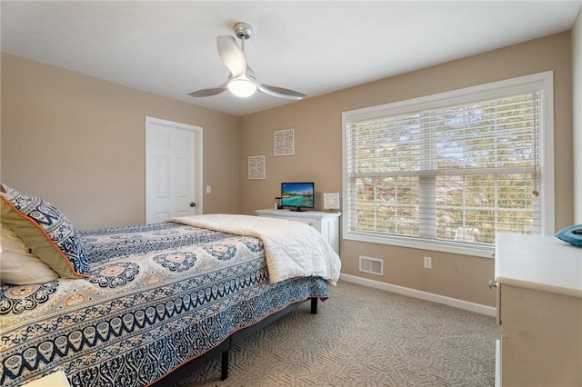 carpeted bedroom with multiple windows, ceiling fan, visible vents, and baseboards