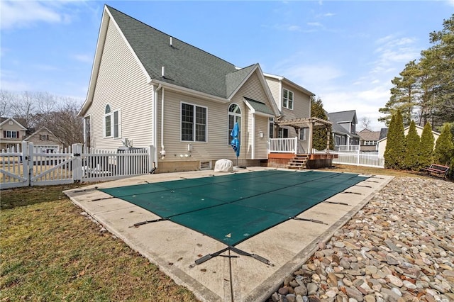 rear view of property featuring a gate, fence, a wooden deck, and a pergola