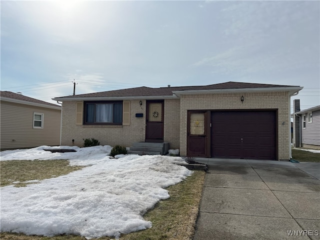 ranch-style home with concrete driveway, brick siding, and an attached garage