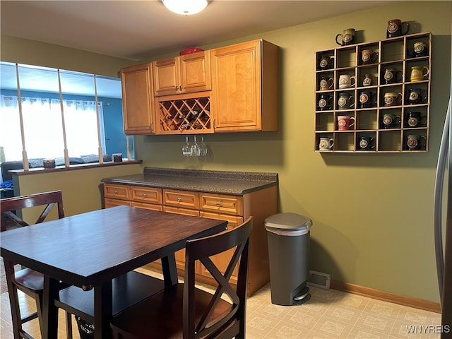 kitchen featuring dark countertops, visible vents, and baseboards