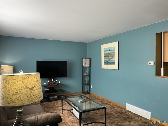 carpeted living area featuring visible vents and baseboards