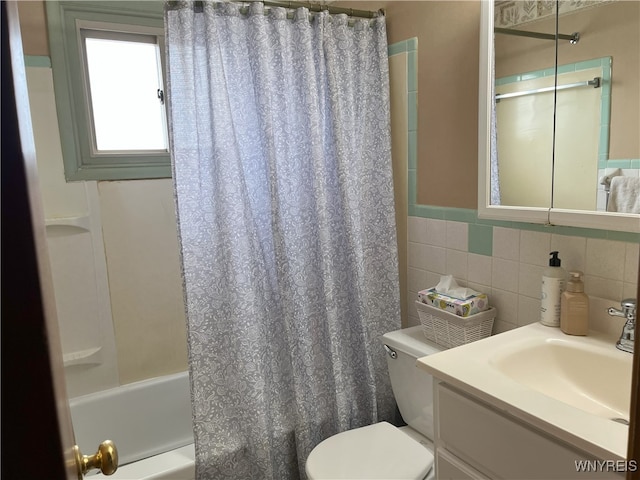 bathroom featuring shower / tub combo, vanity, toilet, and tile walls