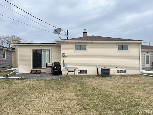 rear view of house featuring entry steps, a patio, a chimney, a yard, and central air condition unit