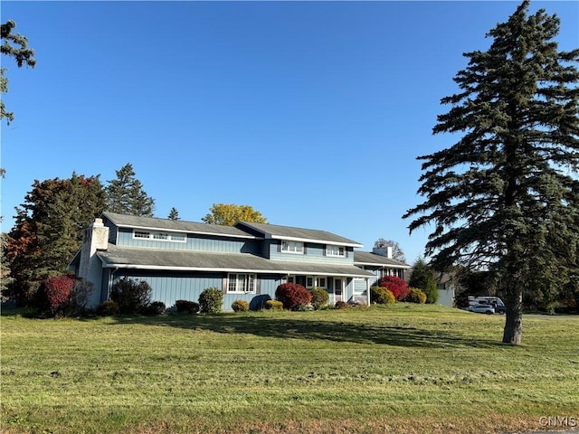 view of front facade with a chimney and a front yard