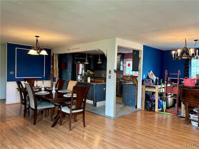 dining room featuring light wood finished floors and an inviting chandelier