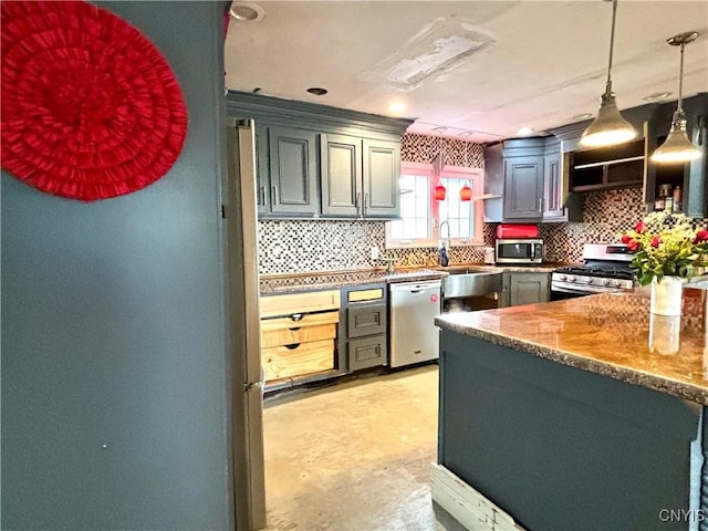 kitchen featuring stainless steel appliances, a sink, hanging light fixtures, and tasteful backsplash