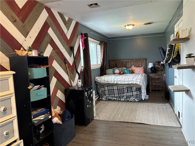 bedroom featuring visible vents and wood finished floors