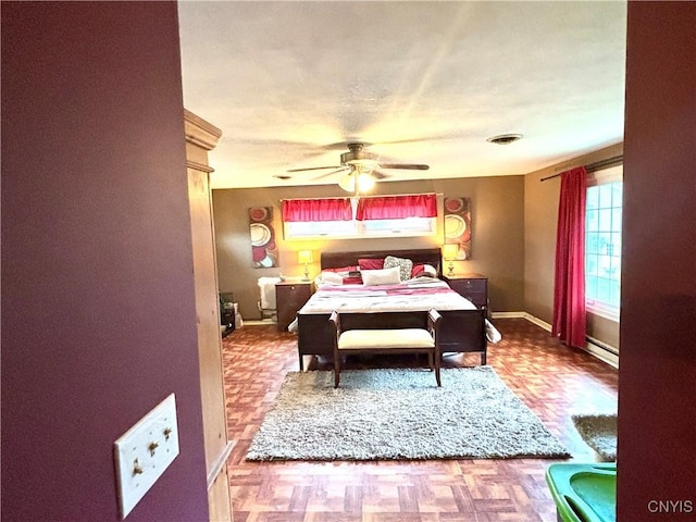 bedroom featuring a baseboard heating unit, visible vents, and baseboards