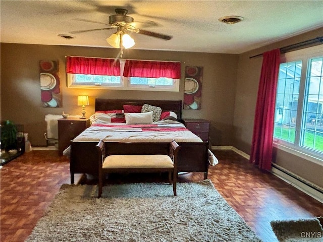 bedroom featuring a textured ceiling, ceiling fan, a baseboard radiator, visible vents, and baseboards